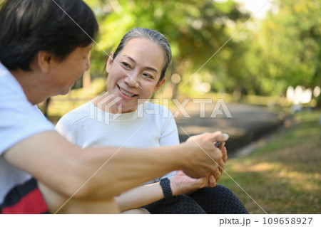 Happy active middle aged couple having fun talking and relaxing in the park. Retirement lifestyle concept Happy active middle aged couple having fun talking and relaxing in the park. Retirement lifestyle concept 109658927