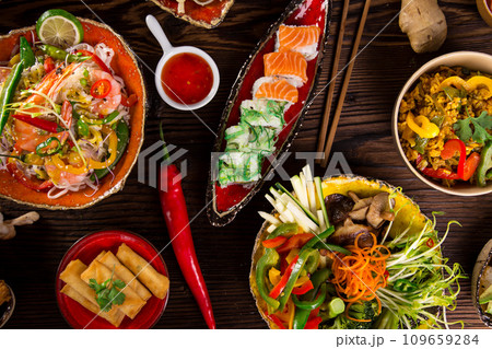 Assorted Asian food set. Chinese noodles, fried rice, dumplings, peking duck, dim sum, spring rolls. Famous Chinese cuisine dishes on table. Top view 109659284