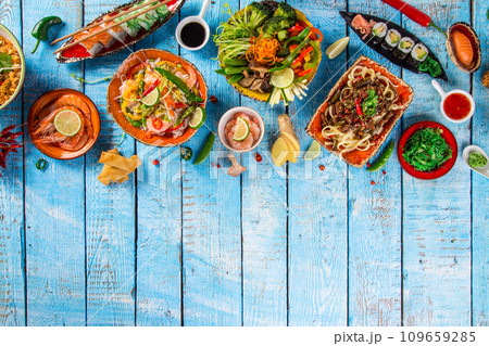 Assorted Asian food set. Chinese noodles, fried rice, dumplings, peking duck, dim sum, spring rolls. Famous Chinese cuisine dishes on table. Top view 109659285