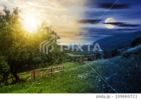 rural landscape with sun and moon at twilight. fence near the apple tree on a hillside meadow. summer solstice day and night time change concept. mysterious countryside scenery in morning light 109660721
