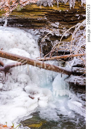 frozen waterfall scenery in winter. ice covered water stream among boulders 109660723