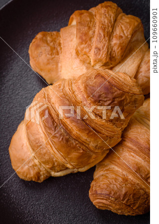 Delicious crispy baked sweet croissants with filling on a ceramic plate 109660901