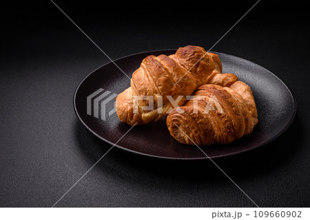 Delicious crispy baked sweet croissants with filling on a ceramic plate 109660902
