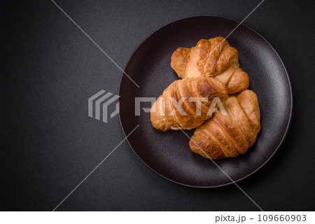 Delicious crispy baked sweet croissants with filling on a ceramic plate 109660903