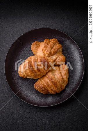 Delicious crispy baked sweet croissants with filling on a ceramic plate 109660904