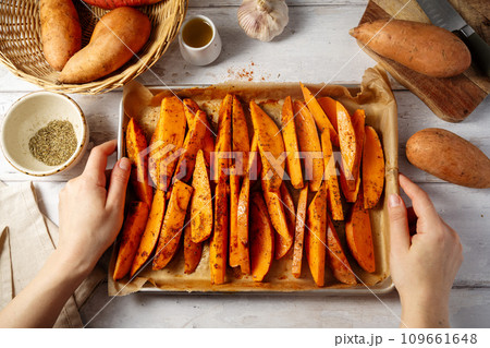 Delicious raw sweet potato wedges, fries on a baking pan. 109661648