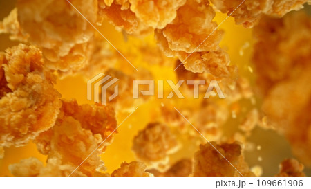 Freeze motion of flying pieces of fried chicken pieces on colored background. 109661906