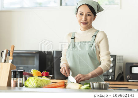 キッチンで料理するエプロン姿の女性 キッチンで料理するエプロン姿の女性 109662143
