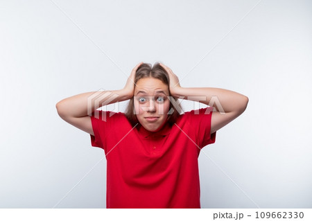 Funny girl with brown hair laughs loudly and holds her head 109662330