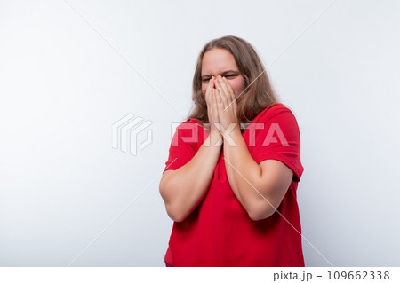 Teen girl is shocked and covers her face with her hands 109662338