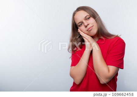 Fair-haired teenage girl dressed in a red T-shirt on a white background 109662458