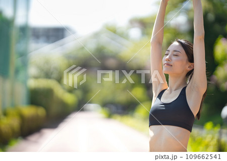 緑の中をランニングするスポーツウエアの若い女性の後ろ姿 109662541