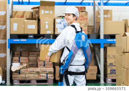 食品倉庫でパワーアシストスーツを着て荷物を持ち上げる女性 食品倉庫でパワーアシストスーツを着て荷物を持ち上げる女性 109663571