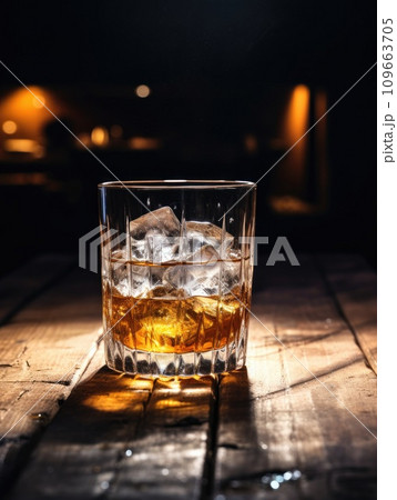 A glass of good whiskey with ice on wooden desk 109663705