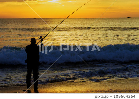 An early morning fisherman catching fish ocean at sunrise An early morning fisherman catching fish ocean at sunrise 109664264