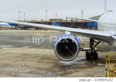 Several passenger planes are being serviced by ground services before next takeoff near boarding gate bridge at airport 109664282
