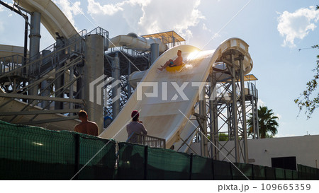 A man screams and rides down a huge high water slide at a water park A man screams and rides down a huge high water slide at a water park 109665359