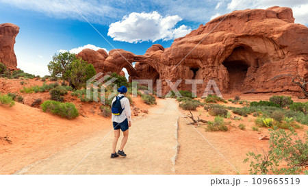 Woman Hiking to Double Arch in Utah National Park 109665519