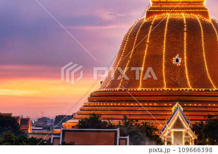 Buddhists climb up to light decoration the golden pagoda Phra Pathom Chedi on sunset sky in annual festive at Nakhon Pathom 109666398