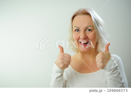 The joy of happiness of approval Plenty of space for text advertising A woman shows class She is very pleased with something And happy She raised her thumbs white background Studio blonde hair 109666573