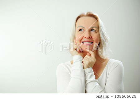 Happy mature blonde lady sitting on couch holding video call with friends, head shot close up portrait. Web cam view laughing middle aged woman having fun, talking with grown up children online 109666629