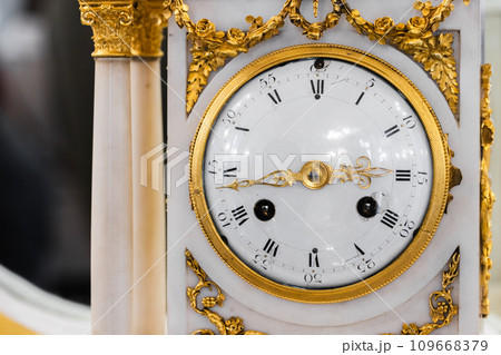 Vintage chiming mantel clock close-up photo, front view. White enamel clock face Vintage chiming mantel clock close-up photo, front view. White enamel clock face 109668379