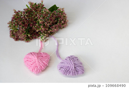 Two hearts pink and lilac on a background of pink flowers. The concept of Valentine's Day, March 8, Family Day, Mother's Day. Two hearts pink and lilac on a background of pink flowers. The concept of Valentine's Day, March 8, Family Day, Mother's Day. 109668490