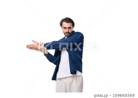 young brutal caucasian man with black hair is dressed in a blue shirt over a t-shirt 109668569
