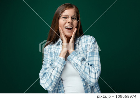 Portrait of an attractive young woman with brown hair on a green background with copy space Portrait of an attractive young woman with brown hair on a green background with copy space 109668974