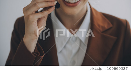Customer service representative with curly hair talking through headset 109669327