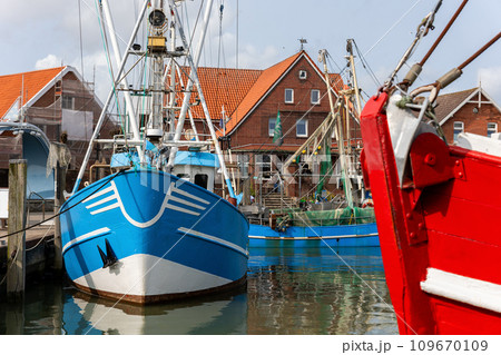 Colorful traditional old german fishing cutter boats moored Neuharlingersiel harbor Wadden sea East Frisia Northern Germany. Commercial fish crab shrimp trawler trawl nets North Sea small port city Colorful traditional old german fishing cutter boats moored Neuharlingersiel harbor Wadden sea East Frisia Northern Germany. Commercial fish crab shrimp trawler trawl nets North Sea small port city 109670109