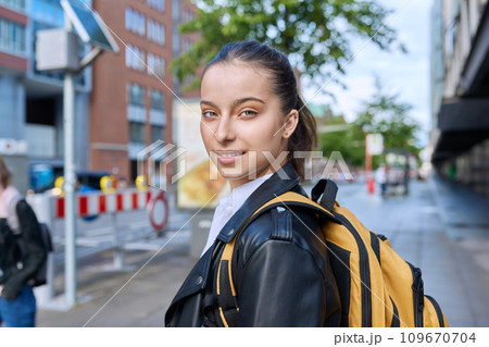 Portrait of teenage high school student girl with backpack on city street 109670704