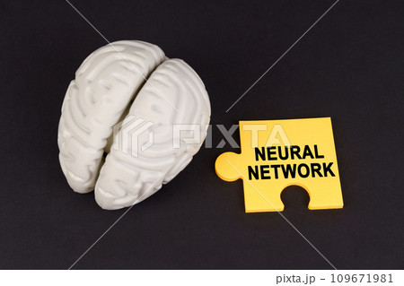 On a black surface lies a brain and a yellow puzzle with the inscription - Neural Network On a black surface lies a brain and a yellow puzzle with the inscription - Neural Network 109671981