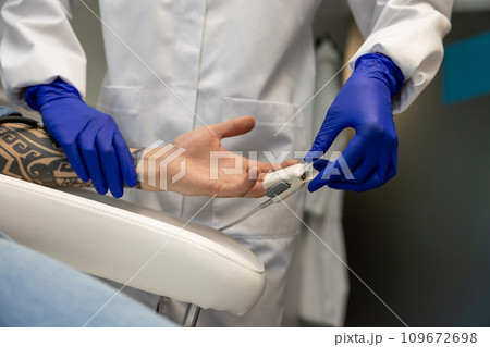 Nurse measuring pressure and oxygen level in male finger. Nurse measuring pressure and oxygen level in male finger. 109672698