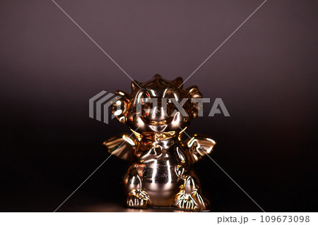 Golden dragon figurine on a black background Golden dragon figurine on a black background 109673098