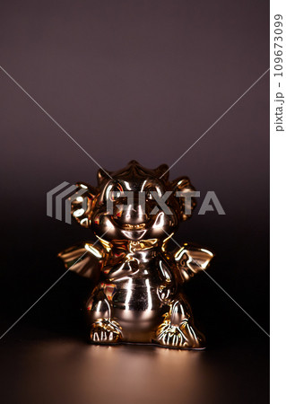 Golden dragon figurine on a black background Golden dragon figurine on a black background 109673099