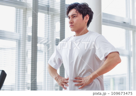 トレーニング施設で腹筋をさわっている男性 109673475