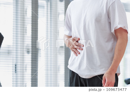 トレーニング施設で腹筋をさわっている男性 109673477