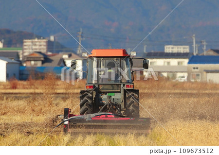 田舎の田んぼを耕すトラクター 109673512