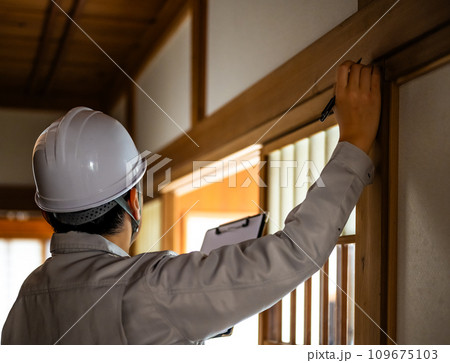 グレーの作業着を着た業者の点検や見積もりシリーズ 109675103