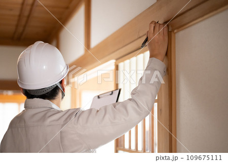 グレーの作業着を着た業者の点検や見積もりシリーズ 109675111