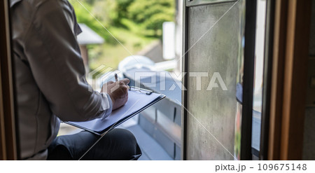 グレーの作業着を着た業者の点検や見積もりシリーズ 109675148