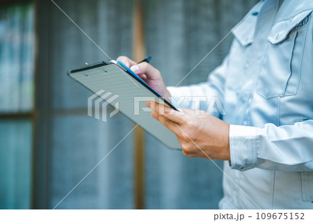 グレーの作業着を着た業者の点検や見積もりシリーズ 109675152