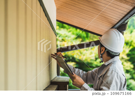 グレーの作業着を着た業者の点検や見積もりシリーズ 109675166