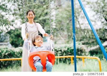公園でブランコをする親子 109675385