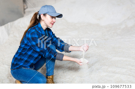 Woman agronomist squatting at bunch of corn flour Woman agronomist squatting at bunch of corn flour 109677533