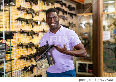 Portrait of man which is choosing air-powered gun in military market Portrait of man which is choosing air-powered gun in military market 109677588