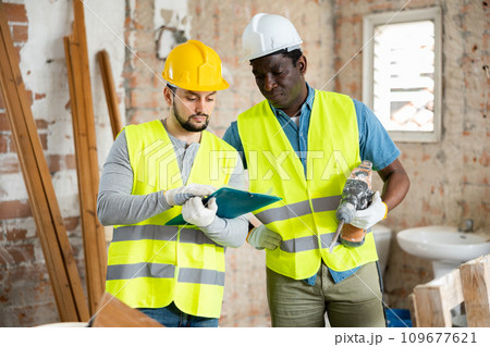 Architects discussing project documentation in construction site 109677621