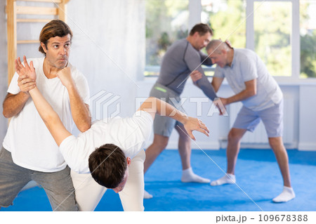 Young guy and man practice wrestling, apply techniques of Aikido and self-defense. 109678388