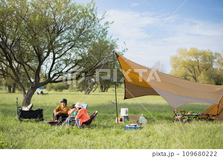 キャンプを楽しむ家族・焚き火でマシュマロを焼くアウトドアイメージ キャンプを楽しむ家族・焚き火でマシュマロを焼くアウトドアイメージ 109680222
